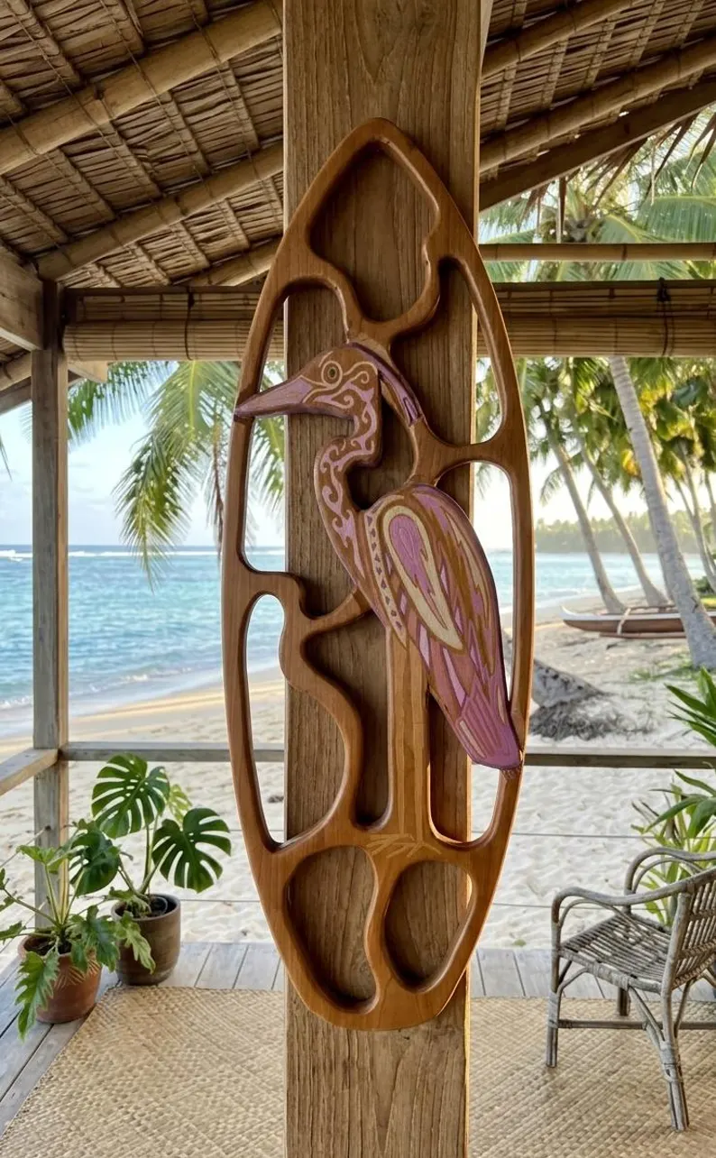 Pink and purple tribal blue heron within a hand-carved open-frame wooden surfboard at a tropical beach