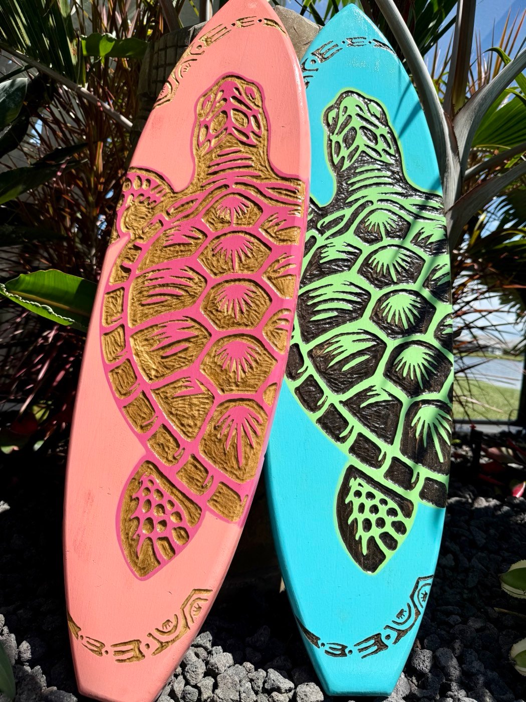 Coral pink and turquoise wooden surfboards hand-carved with gold and black honu sea turtle shells and Polynesian bands at the tip and tail