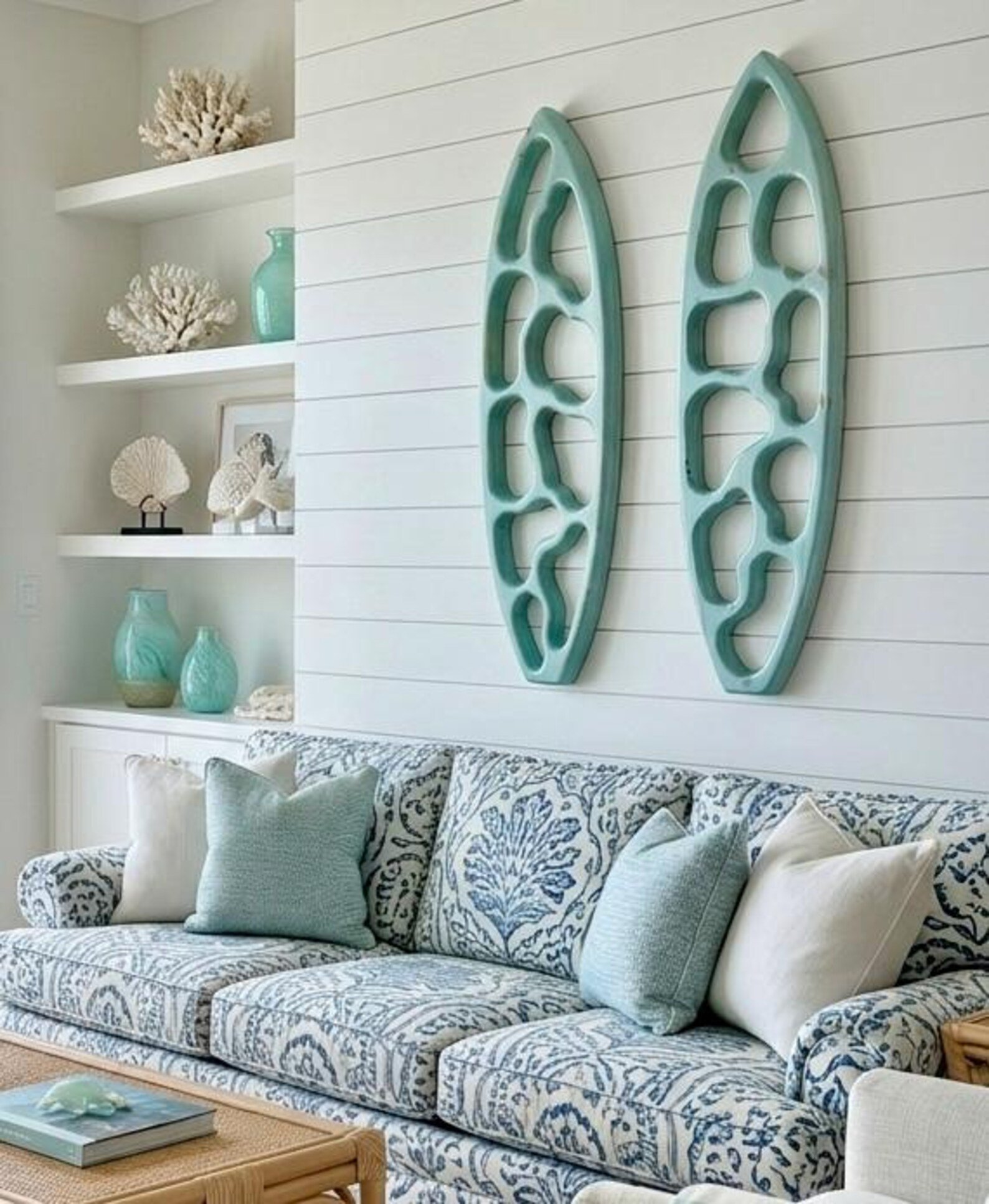 Two aqua hand-carved ripple surfboards in a coastal living room